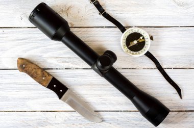 Optik görüş, av bıçağı ve vintage pusula. Avcılık kompozisyon.