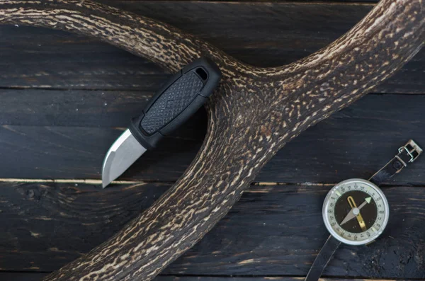 Knife and compass on a black background. Outdoor.