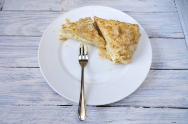 Napolyon kek. Pasta tatlı çatal ile beyaz tabakta. Beyaz arka plan.