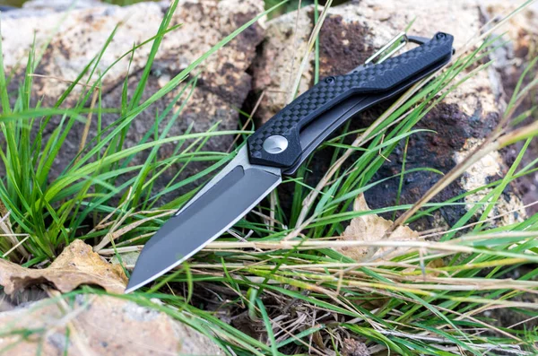 Folding knife with a black handle and a gray blade.