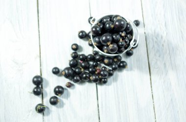 Blackcurrant çilek beyaz kova. Beyaz ahşap arka plan. Rustik tarzı.