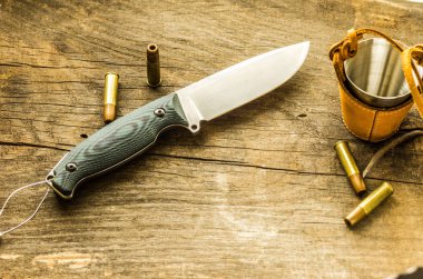 Kompozisyon bir av bıçağı ve mermi. Av gereçleri ve madde işaretleri.