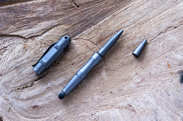 Metal ballpoint pen for self-defense. A tool for self-defense. Wooden background.