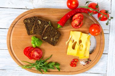 Sebze, ekmek, baharatlar ve peynir kesme tahtası üzerinde. Sandviç.