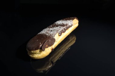 Tatlı pasta siyah bir arka plan üzerinde. Kek krem içinde. Karanlık ruh hali.