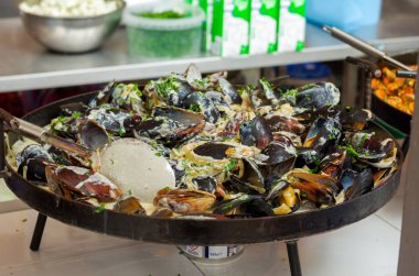 Midye hazırlanması. Bir tavada midye. Sokak gıda.