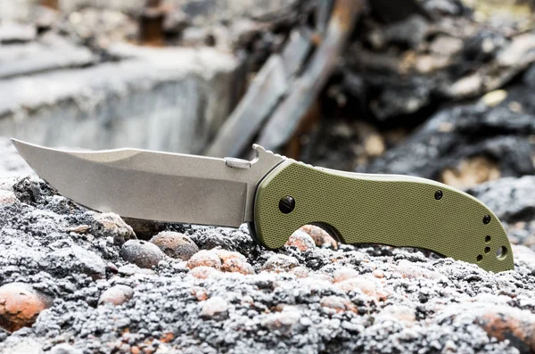 Military pocket knife close-up. Green plastic handle.