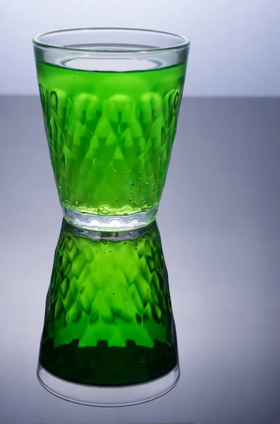 Glas mit grünem Getränk. Grün auf Schwarz. — Stockfoto