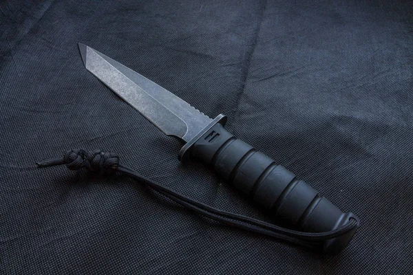 Black knife on a black background for the military.