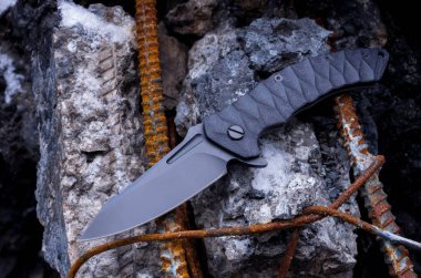 Flipper bıçakla katlanır. Arka plan beton ve takviye bıçakta.