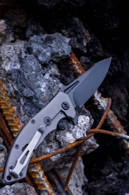 Küçük resimlerden birinin üzerinde cep bıçak. Bıçak dikey çerçeve.