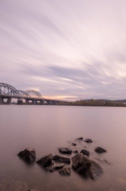 Günbatımı Nehri. Kentin gün batımı. Taşlar ön planda.