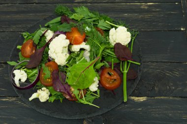 Çeşitli sebze salatası. Çok renkli salata. Bir tabak üzerinde üstten görünüm.