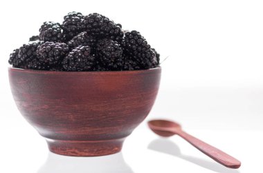 Tam blackberry çanak. Kil plaka ve tahta kaşık. Hala kırsal.