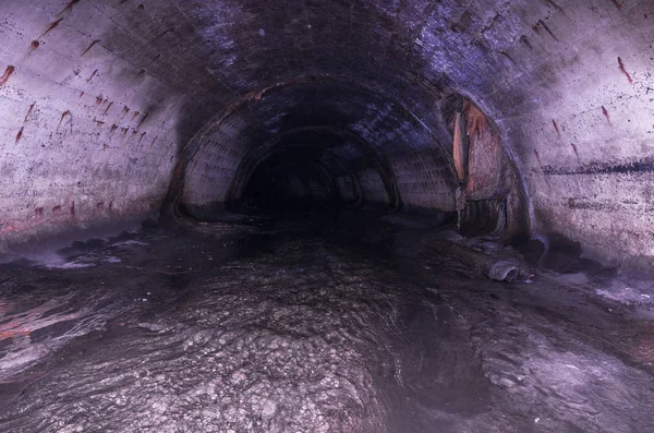 地下一条狭窄的椭圆形隧道 污水路面 地下河 — 图库照片