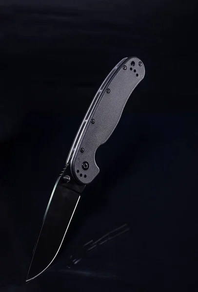Black knife on a black background. American knife. Knife of a military man. — Stock Photo, Image