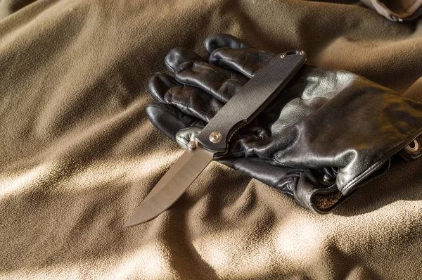 Czarny, składany nóż i czarną rękojeścią. Promienie słońca na nóż. — Zdjęcie stockowe