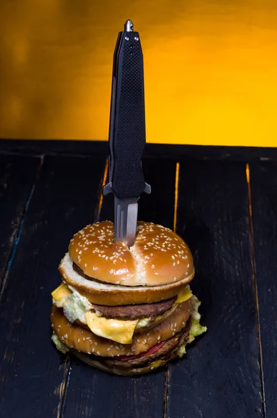 Burger με κρέας διαπερνημένος με ένα μαχαίρι. Θέα από το μπέργκερ από πάνω. — Φωτογραφία Αρχείου