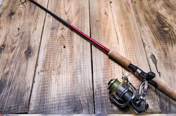 Pesca girando com carretel. Vara de pesca em um fundo de madeira . — Fotografia de Stock