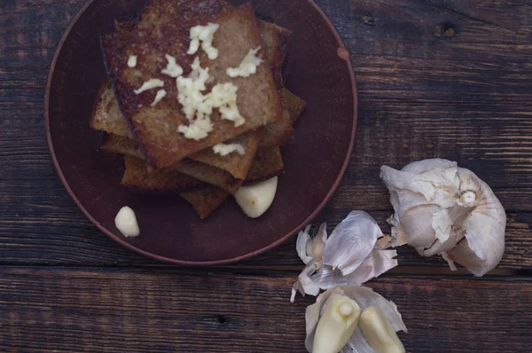 Fried bread with garlic. Peeled garlic and croutons. — Stock Photo, Image