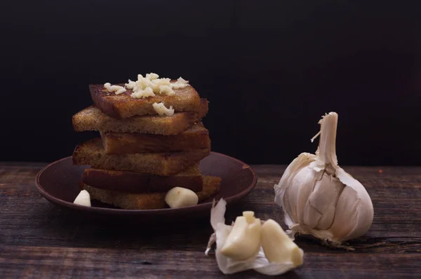Homemade croutons with garlic. Croutons on the plate. Dark still life. — Stock Image Homemade croutons with garlic. Croutons on the plate. Dark still life. Stock Photo