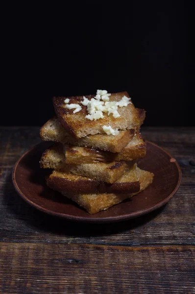 Croutons on a clay plate. Toast with garlic. — Stock Image Croutons on a clay plate. Toast with garlic. Stock Image
