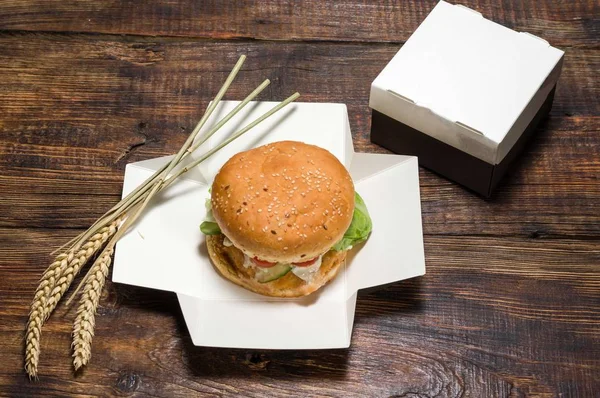 Burger and spikelets of wheat. Burger in the box.