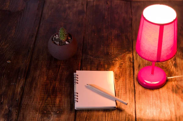 Roze nachtlampje en notebook met potlood. Nachtlampje op het Bureau. — Stockfoto