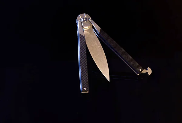 Butterfly knife in semi-complicated condition. Butterfly knife on a black background. — Stock Photo, Image