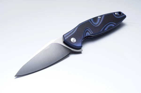 Folding knife on a gray background. The location of the knife diagonally. — Stock Photo, Image