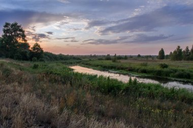 Bir nehir ve bir alan ile güzel manzara. Tarlada güzel gün batımı.