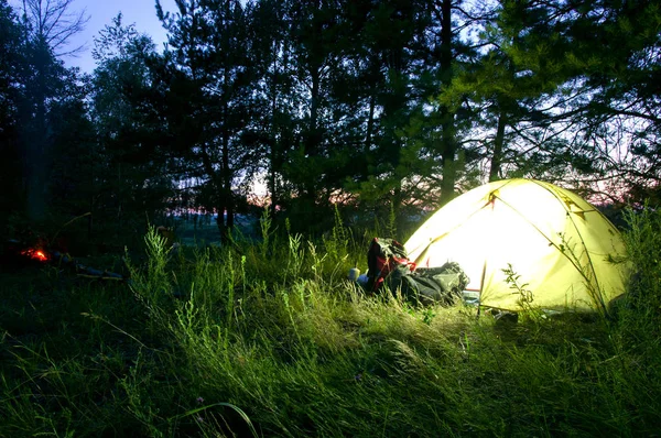 Luminous tourist tent night. Tourist tent in the forest.