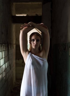 Terk edilmiş bir odada poz veren kız. Beyaz bir kadın portresi.