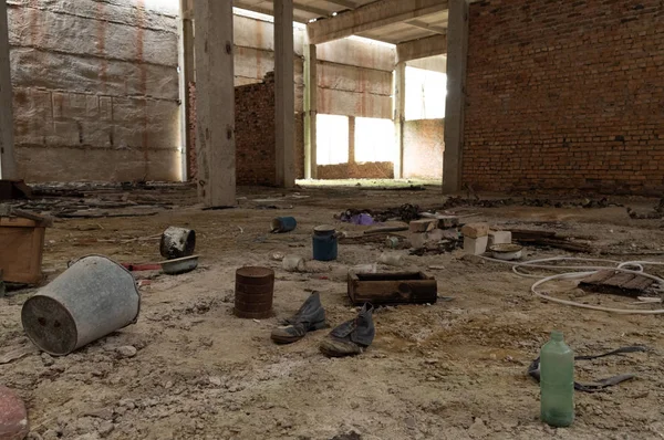 Los restos de cosas humanas en una habitación abandonada. Zapatos y platos . —  Fotos de Stock