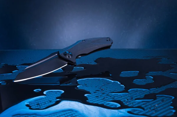 Μαχαίρι με μαύρη λεπίδα και λαβή. Μαχαίρι και χυμένο νερό. — Φωτογραφία Αρχείου