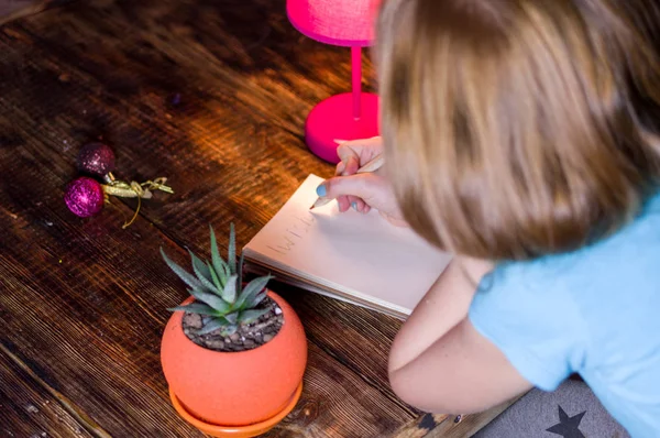 Het meisje maakt een wens. Meisje schrijft een wens. Wachten op een verrassing. — Stockfoto