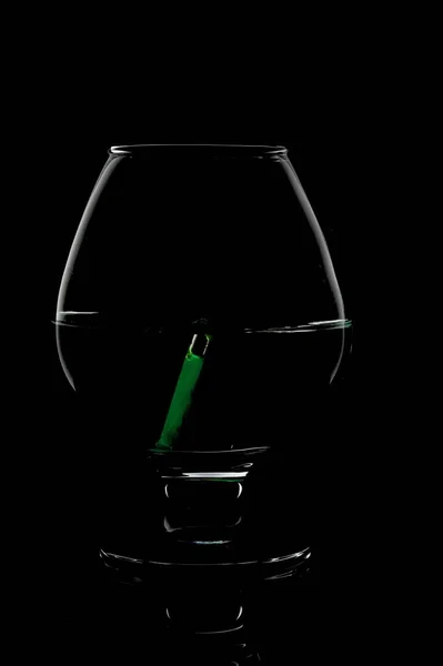 Photo d'une tasse en verre sur fond noir. Des trucs verts dans un verre. — Photo