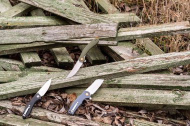 Tahta tahtalarda üç bıçak var. Doğadaki bıçakların fotoğrafı. Açık hava..