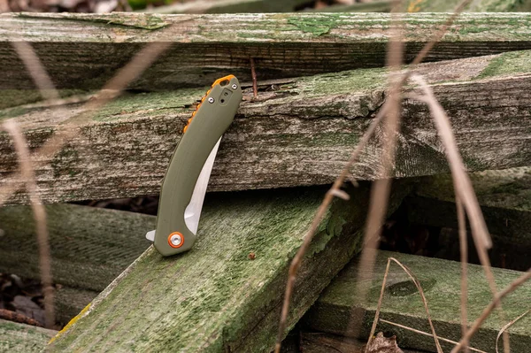 Folding knife in the folded position. Blade of a knife hidden in the handle. Top.