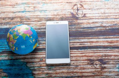 Akıllı telefon ve küre. Dünya çapında iletişim..