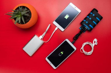 Elektrik bankalarından iki karışık akıllı telefon şarj ediliyor. Farklı akıllı telefonlar ve elektrik bankaları.