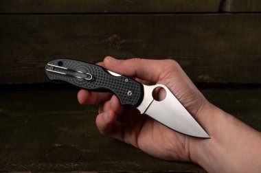 Elinde çakı var. Plastik saplı ve şarjörlü bıçak. Bıçağı elinde tut. Delikli bıçak..