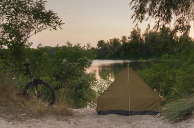 Nehir kenarında bir çadırda dinlen. Kumlu sahilde turist çadırı. Akşamları nehir kenarında.