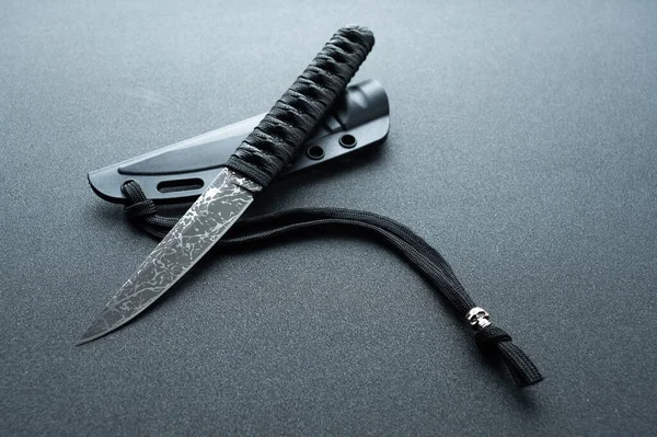 Cuchillo de estilo japonés. Un cuchillo negro estrecho con un patrón y un cordón. — Foto de Stock
