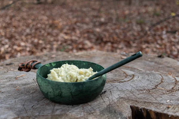 Mashed potatoes in a bowl with a spoon. Outdoor food. Front view.