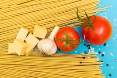 Mavi bir arka plan üzerinde makarna yemek pişirmek için malzemeler bir dizi.