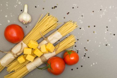 Gri bir arka plan üzerinde klasik bir makarna tarifi. Makarna ve sebzeler.