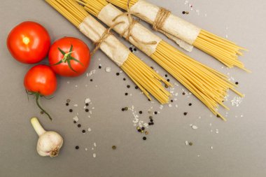 Gri bir arka planda üstten görünüm makarna yemek pişirmek için malzemeler bir dizi.
