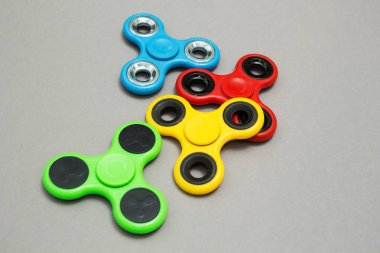 Çok renkli gri arka plan üzerinde parmak spinner stres kıpır.