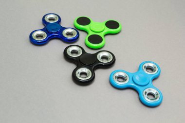 Gri arka plan üzerinde renkli topluca parmak spinner stres.